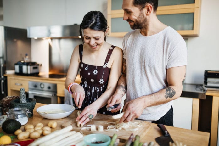 A mature couple in their kitchen preparing food for a dinner party later this evening