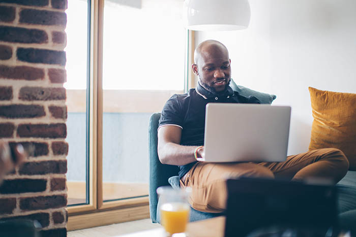 man sitting in home living room on laptop