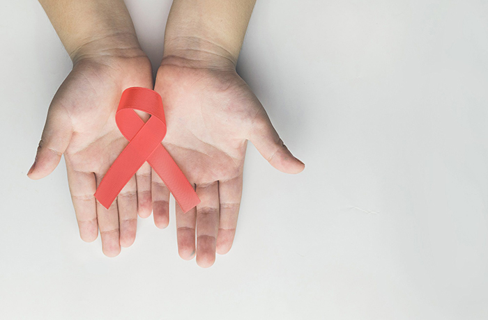hands holding hiv red ribbon