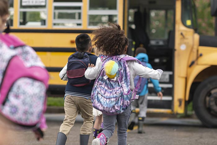 Kids running to a School bus 