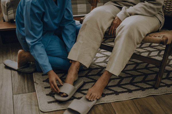 caregiver helping to dress loved one
