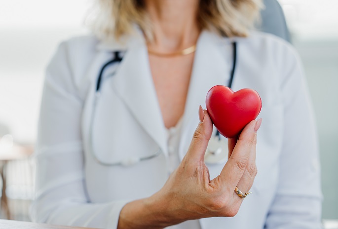 woman physician holds heart stress ball