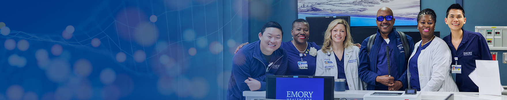 a diverse group photo of emory nurses smiling at the nurses station