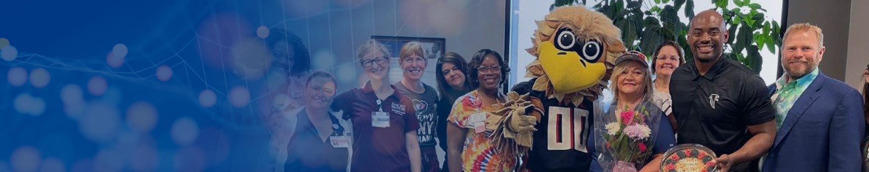 emory employees posing with atlanta falcons mascot