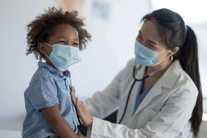 A happy child being examined by a doctor