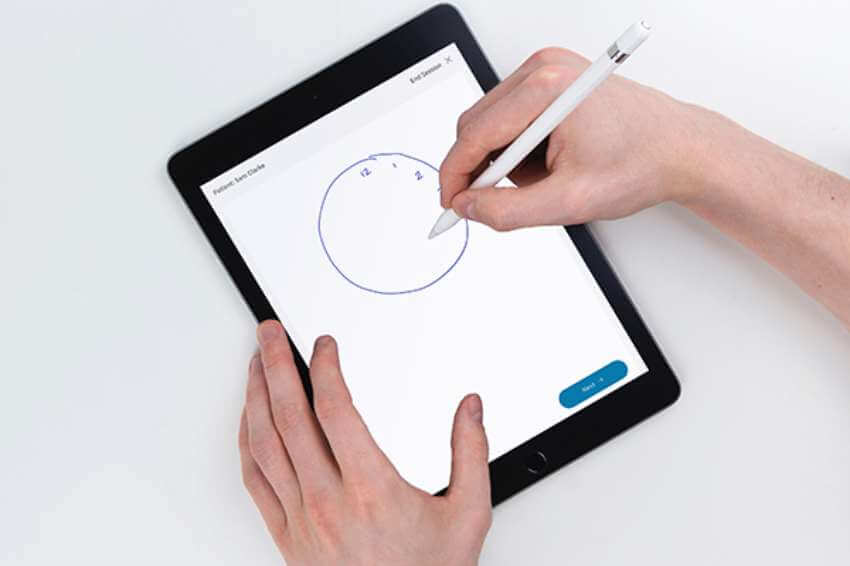 hands drawing a clock on a tablet for a dementia test