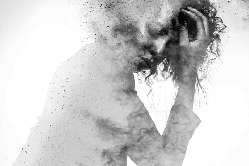 a black and white illustration of a stressed woman with her eyes closed and her head in her hands