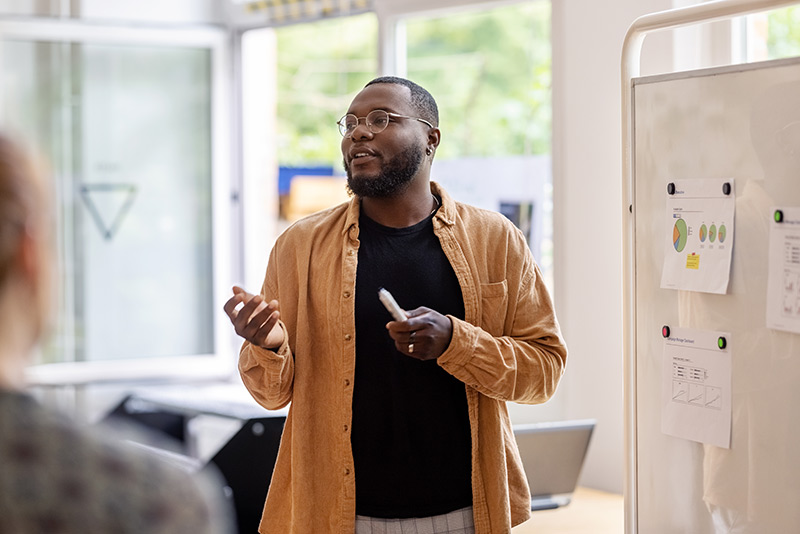 A teacher in front of a classroom talking to a group of people