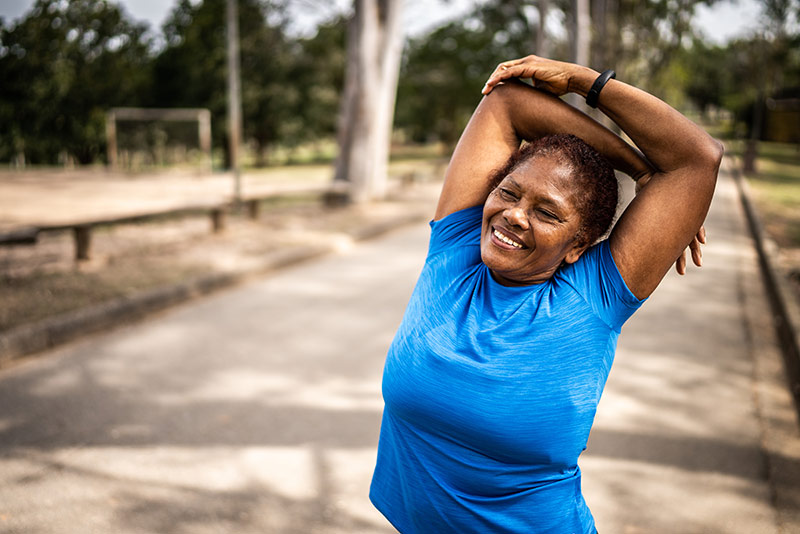 woman stretching on a walking trail