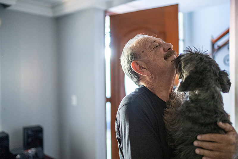 dog kissing elderly man