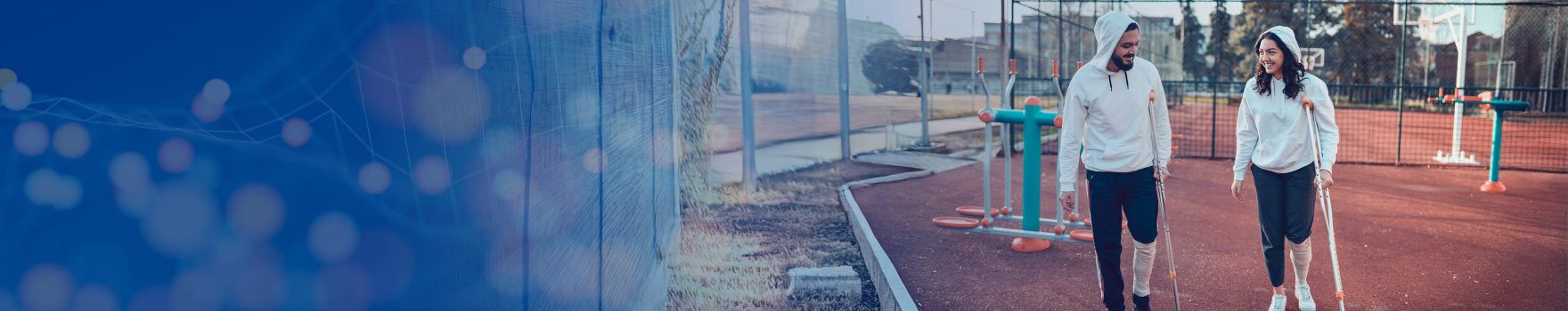 man and woman on crutches at outdoor exercise court