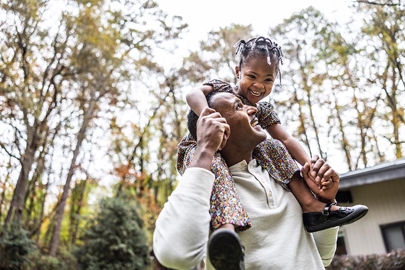 man with little girl on his shoulders